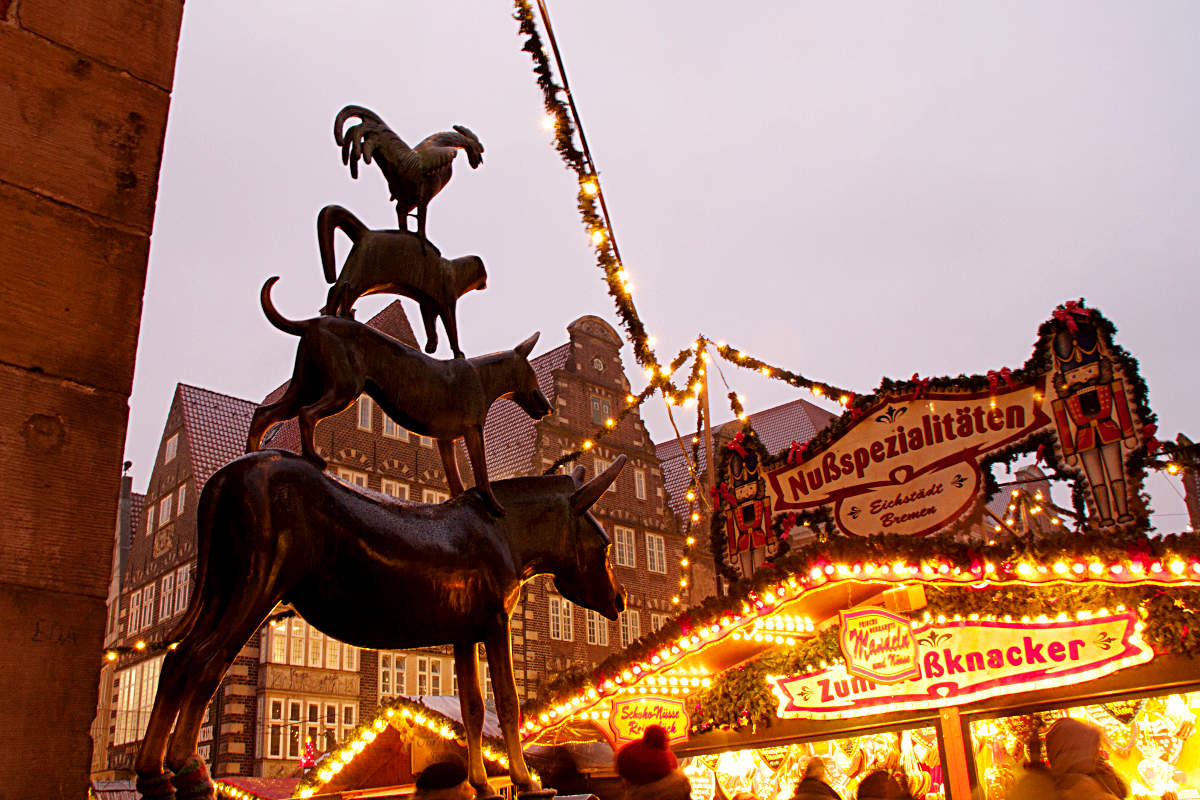 Die Bremer Stadtmusikanten mit Blick auf den Weihnachtsmarkt