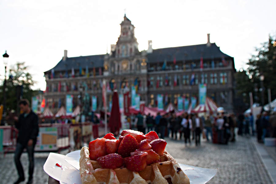 Belgische Waffel mit Erdbeeren vor dem Rathaus von Antwerpen